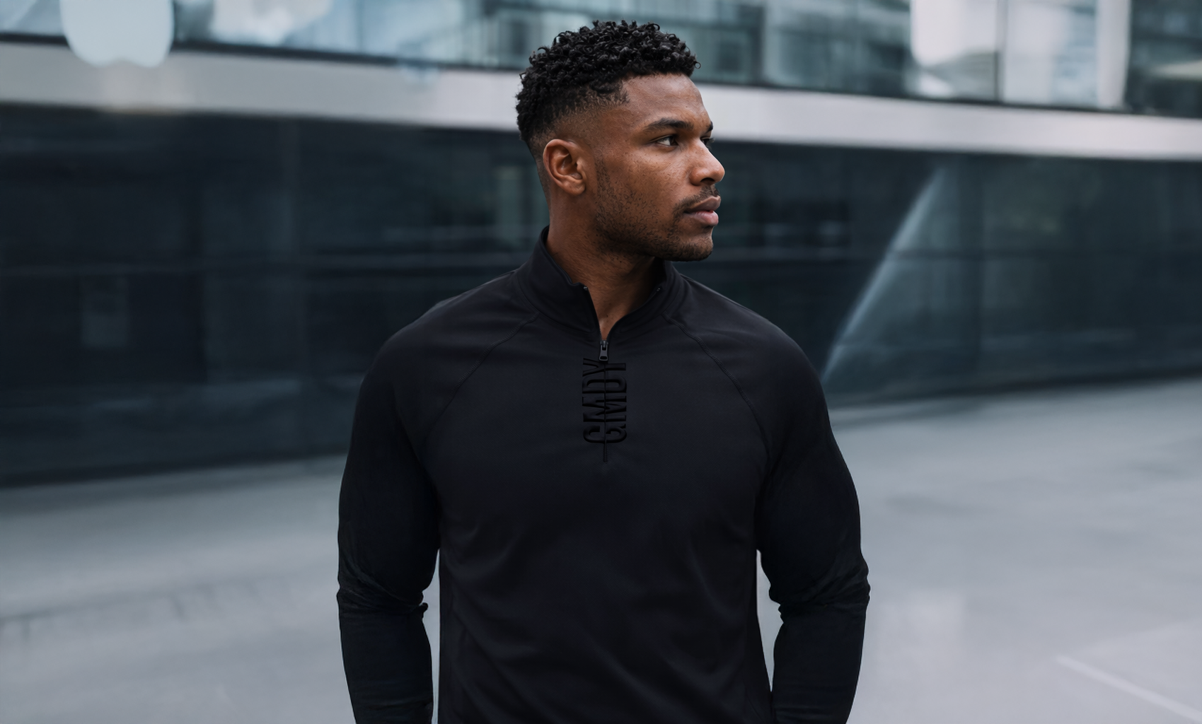 Man wearing a black outfit standing in an urban setting